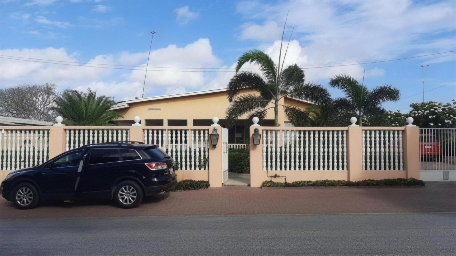 Before: the original house with a white fence